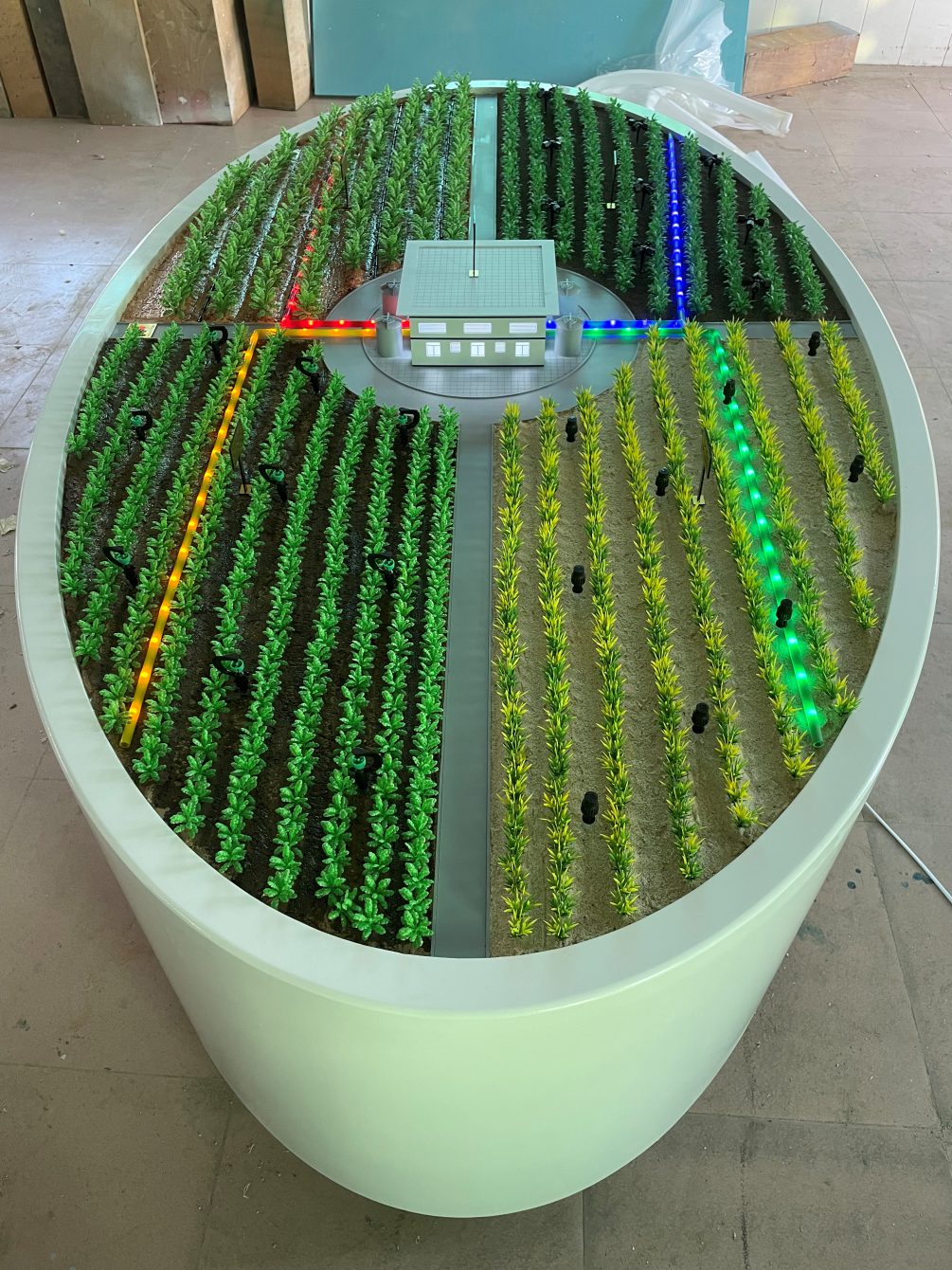 Circular farmland model with rows of green indicator lighting